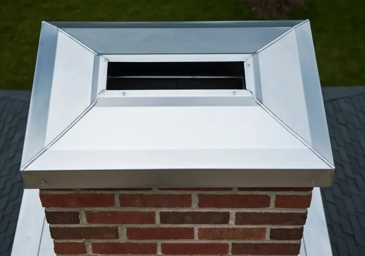 After — chimney cap installation: A bare, weather-open flue finished with a stainless cap against rain and nesting animals.