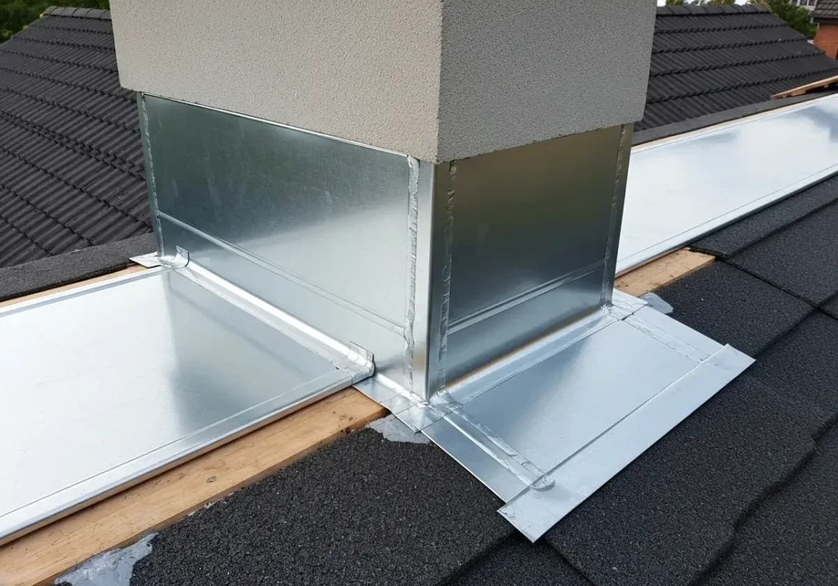 After — chimney flashing repair: New step and counter-flashing at the roofline, replacing the rusted metal that leaked.