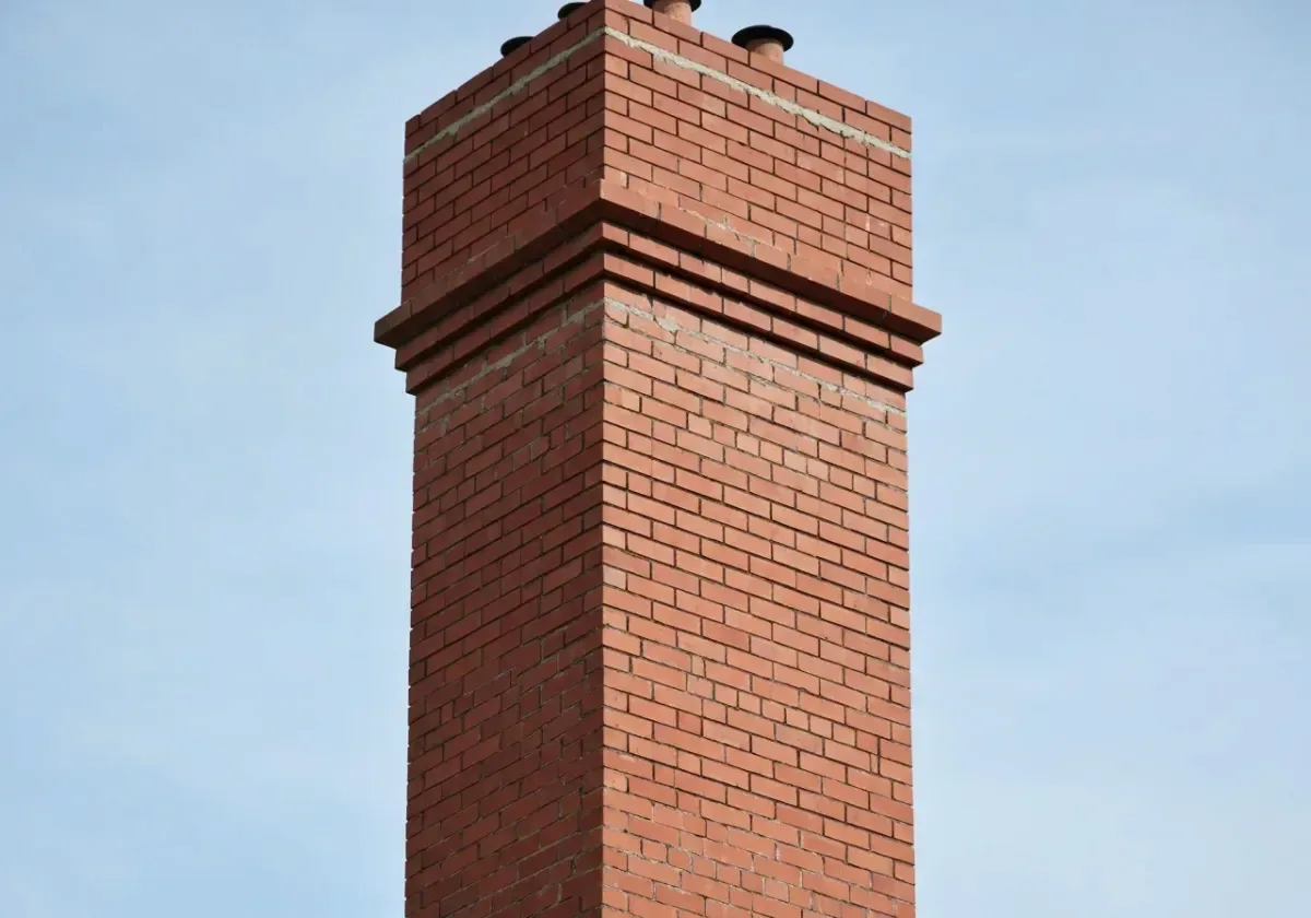 After — chimney repair: Spalled courses and washed-out joints rebuilt into a stack that sheds rain again.